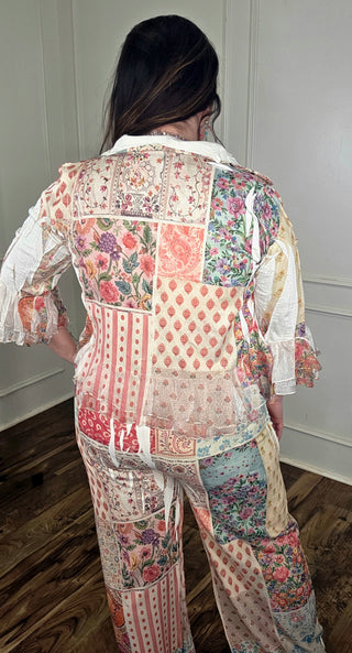 Person wearing a patchwork floral outfit in a room with wooden flooring.