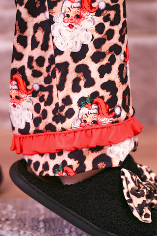 Close-up of the pajama pant hem with red ruffle trim on the leopard Santa print